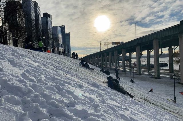 A photo of kids sledding on the UWS